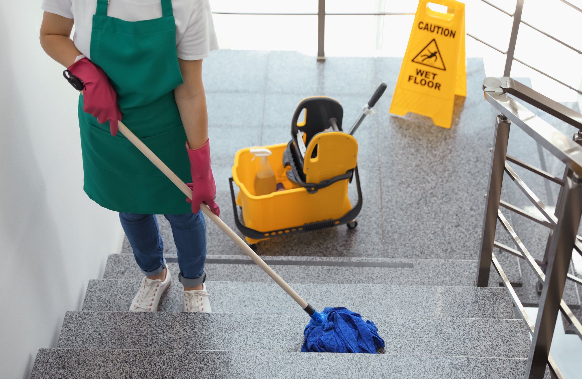 Young Woman with Mop Cleaning Stairs